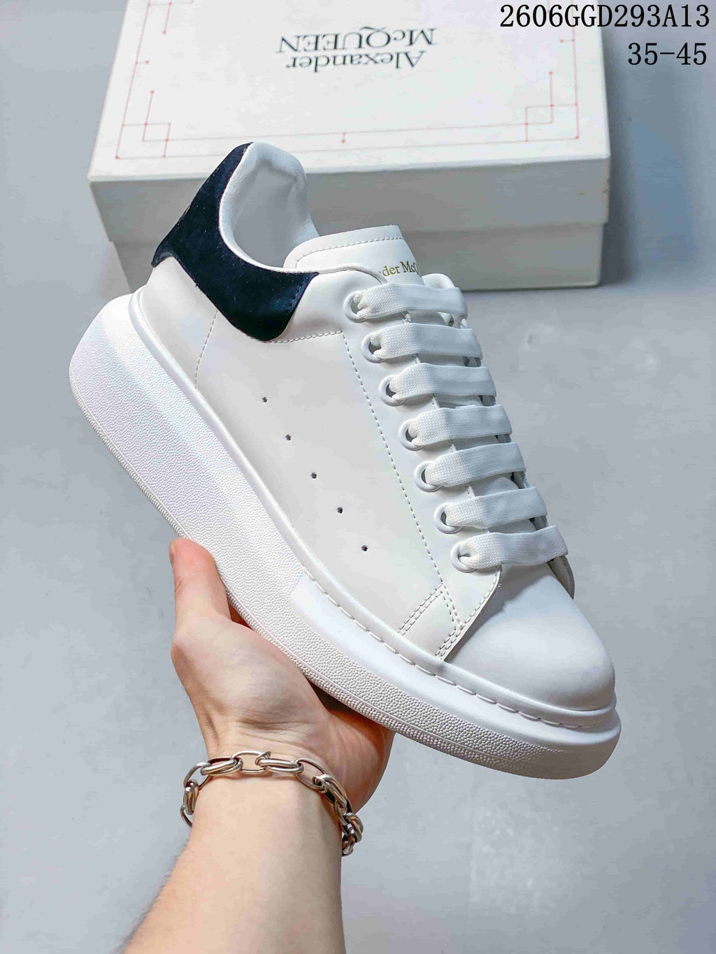 Angled view of a white low-top sneaker with black heel tab and chunky sole