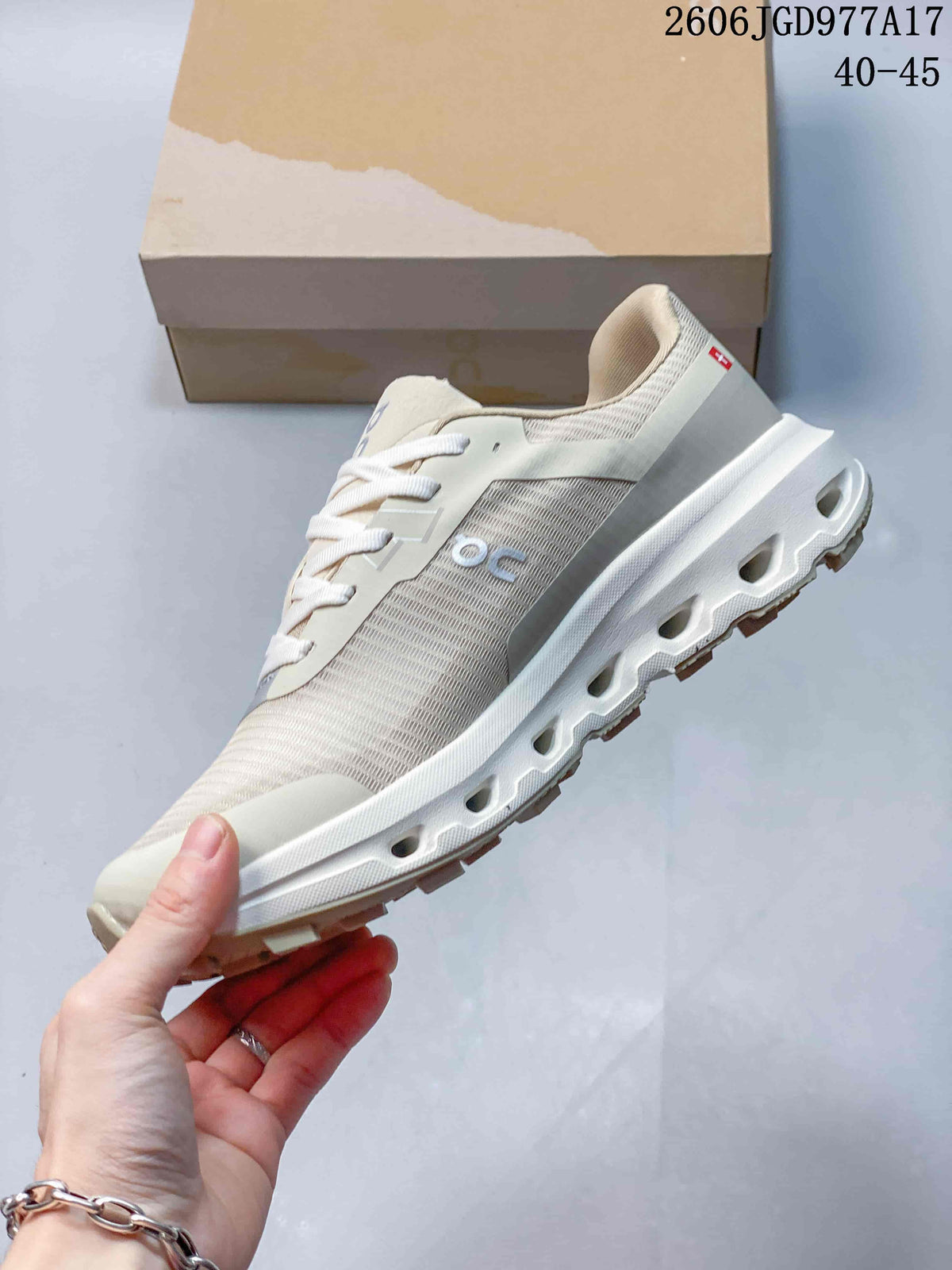 Side profile highlighting the beige upper, On branding and lugged outsole.