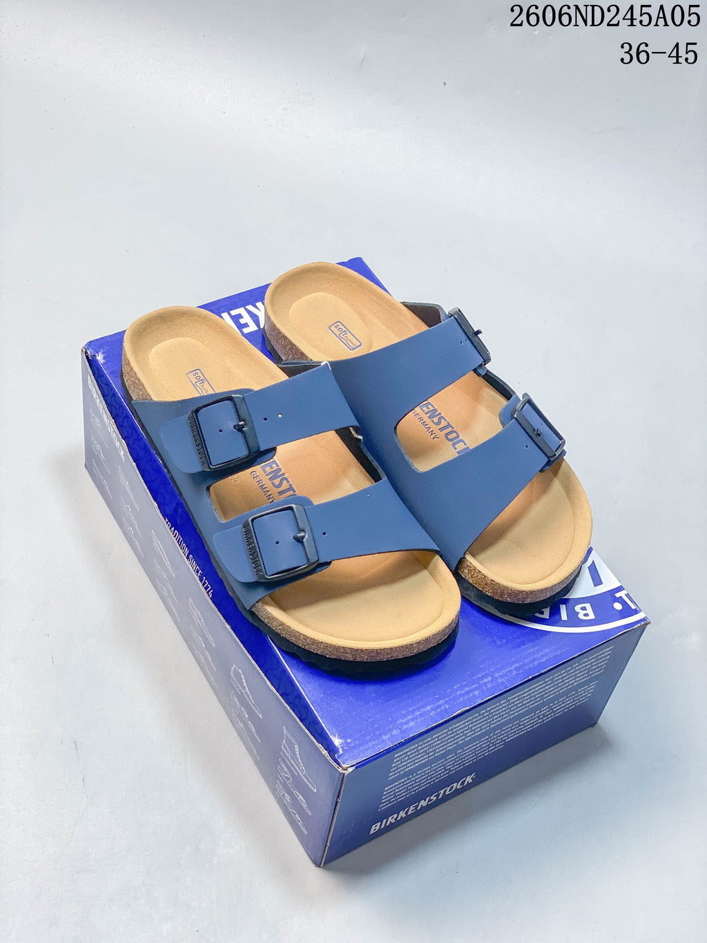 Blue two-strap buckle sandals with a contoured footbed, shown on a blue shoebox; image overlay states sizes 36–45.