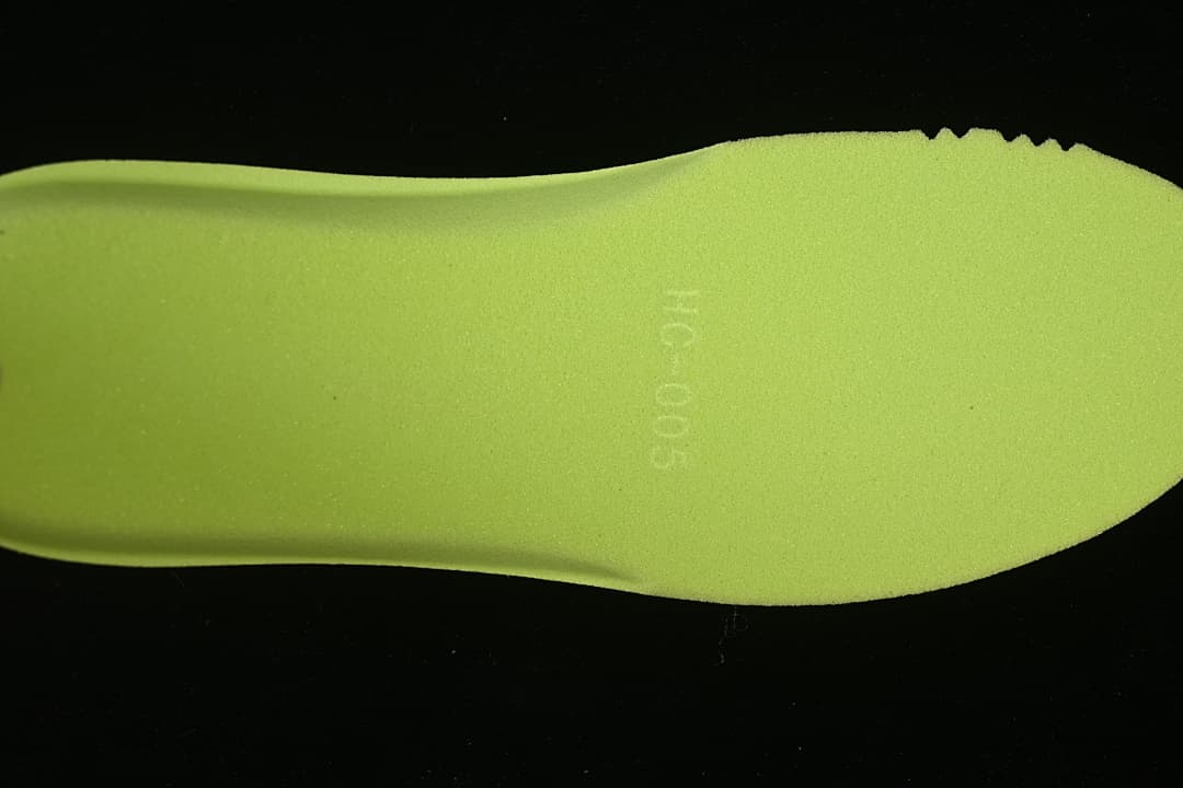 Bright green insole shown separately against a dark background.