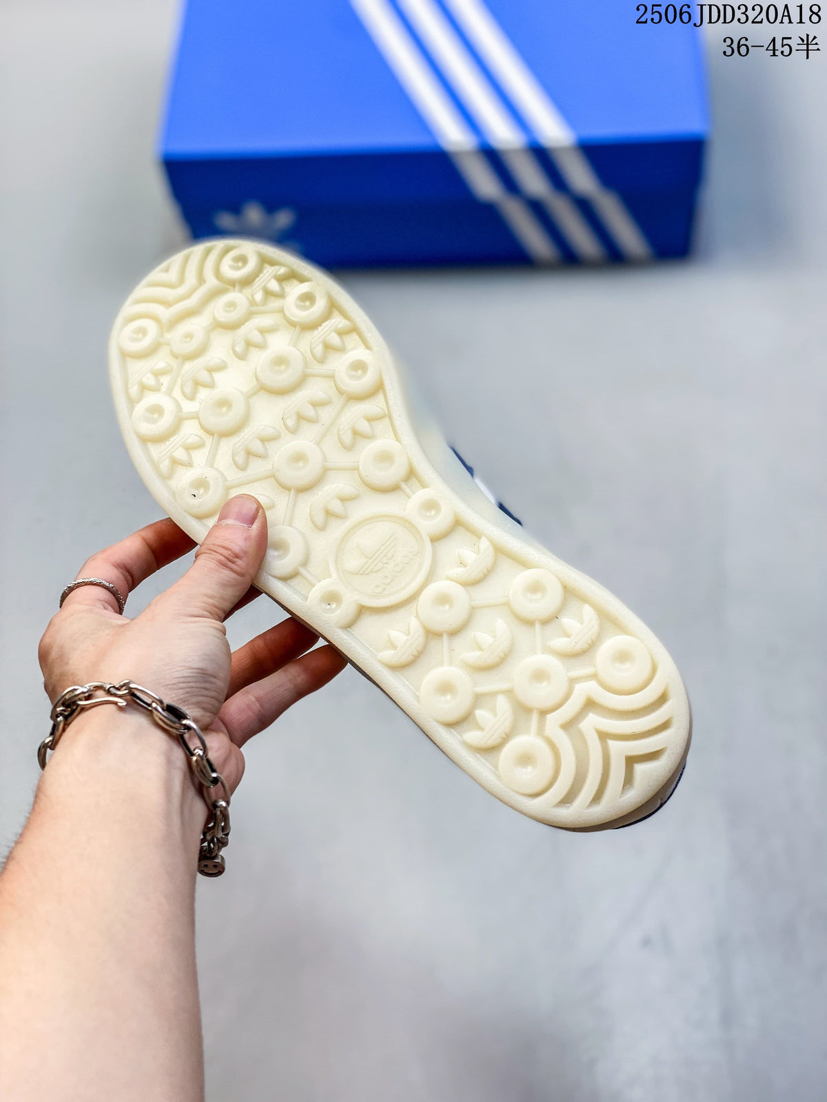 Underside of a cream sneaker showing a patterned rubber outsole.