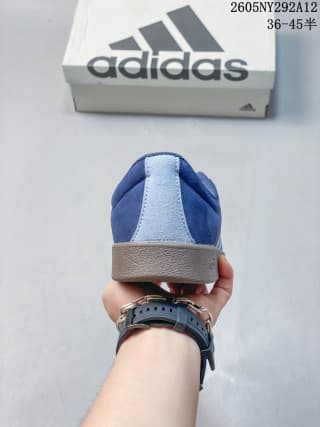 Rear view of the blue sneaker showing the heel, gum-style sole, and Adidas shoebox.