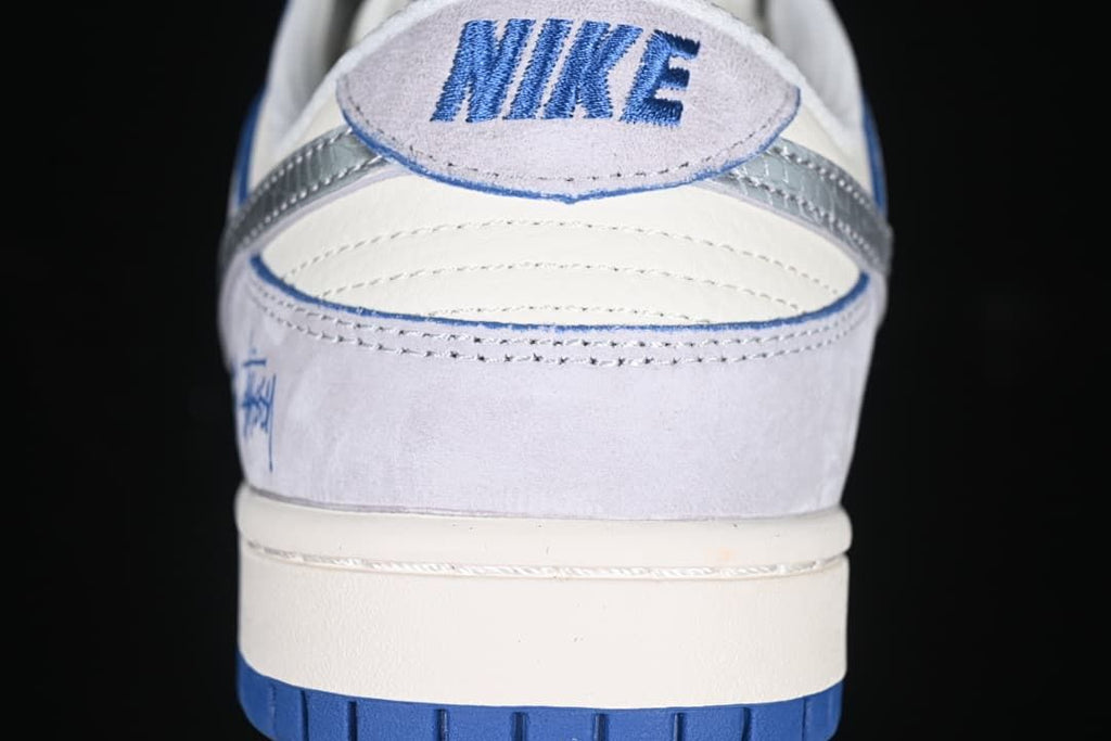 Rear view showing the heel panel, blue embroidery, and two-tone outsole
