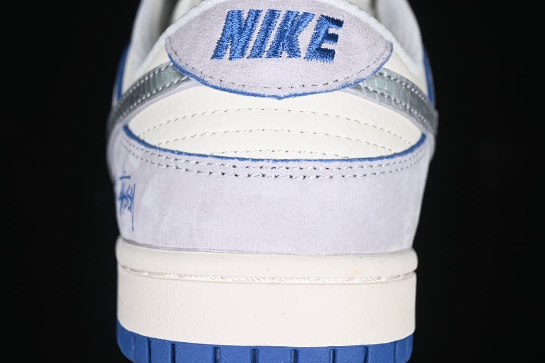 Rear view showing the heel panel, blue embroidery, and two-tone outsole