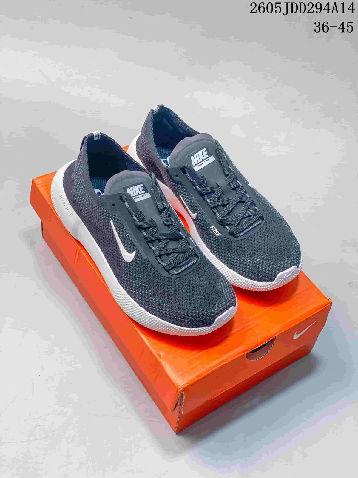 Pair of charcoal gray and white Nike Free low-top running shoes on an orange shoe box