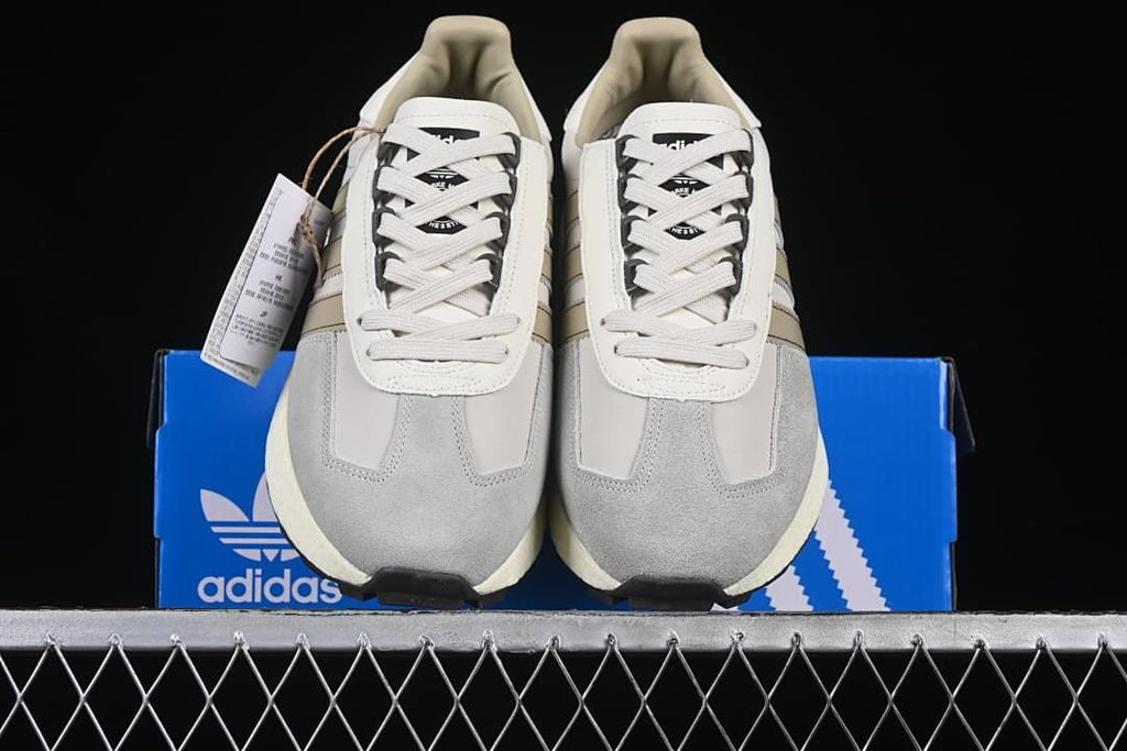 Front view of the pair of grey and white lace-up sneakers displayed on the box
