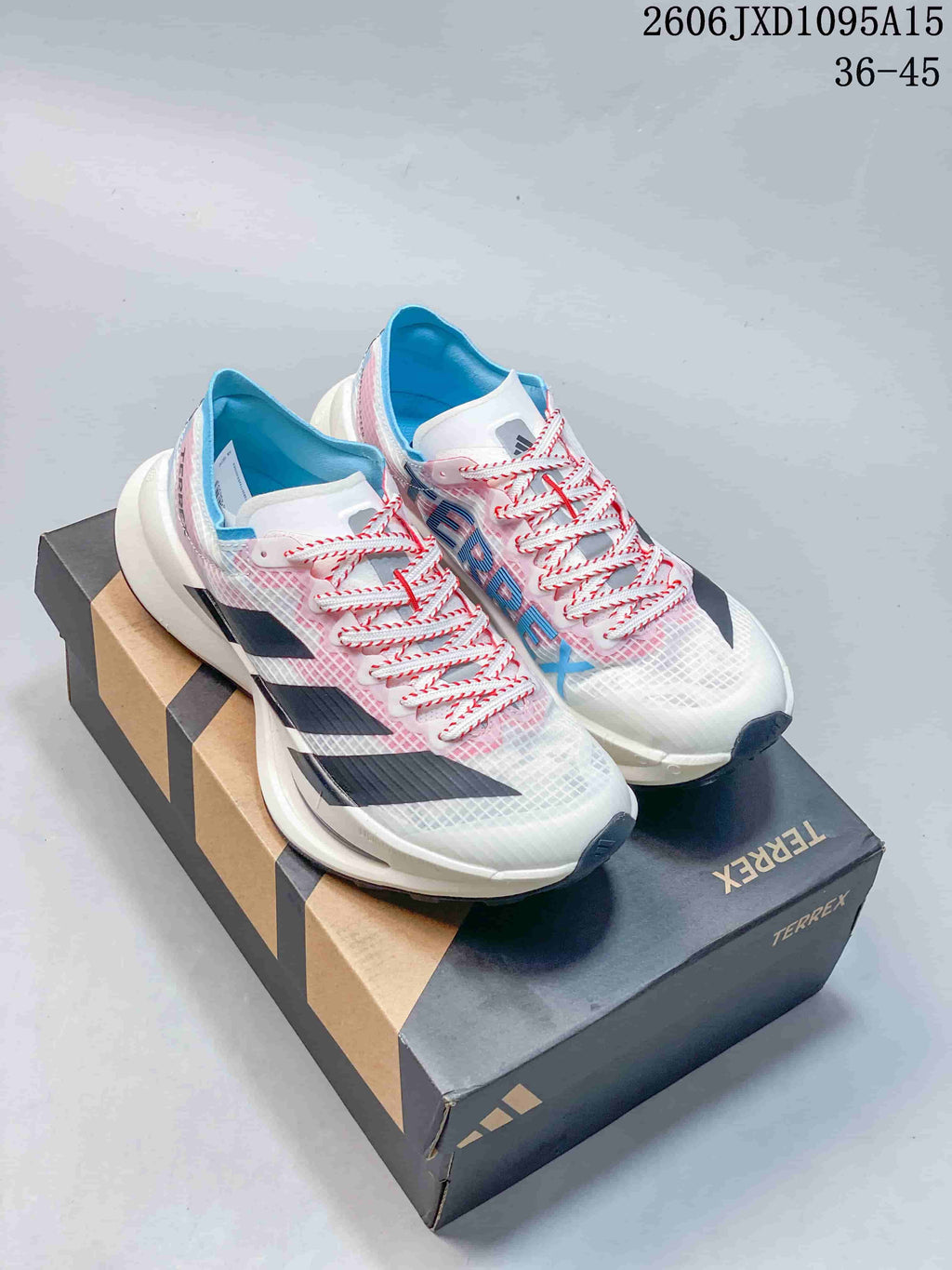White Adidas Terrex shoes with pink and blue accents on a branded box