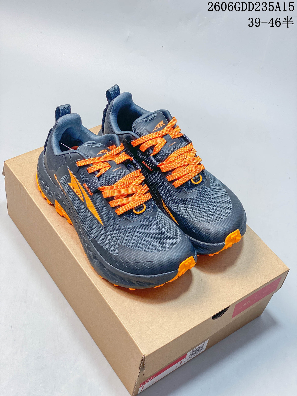 Pair of dark gray Altra trail shoes with bright orange laces and outsole accents.