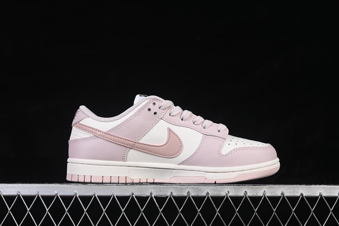 Side profile of one pale pink and white low-top sneaker