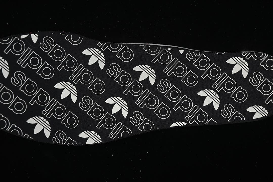 Removable insole shown with a black-and-white adidas Trefoil pattern.