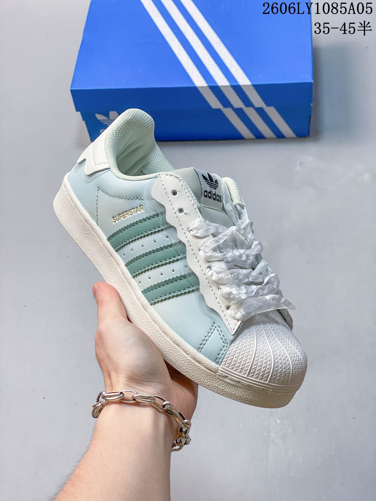 Angled side view of the pale blue and off-white Superstar sneaker