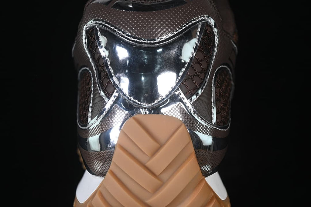 Rear view of the sneaker showing reflective silver-tone panels and the tan outsole.