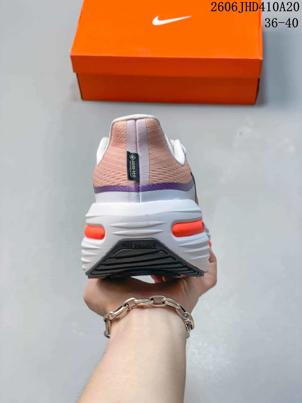 Rear view showing the heel and midsole of the pink-toned Nike running shoe