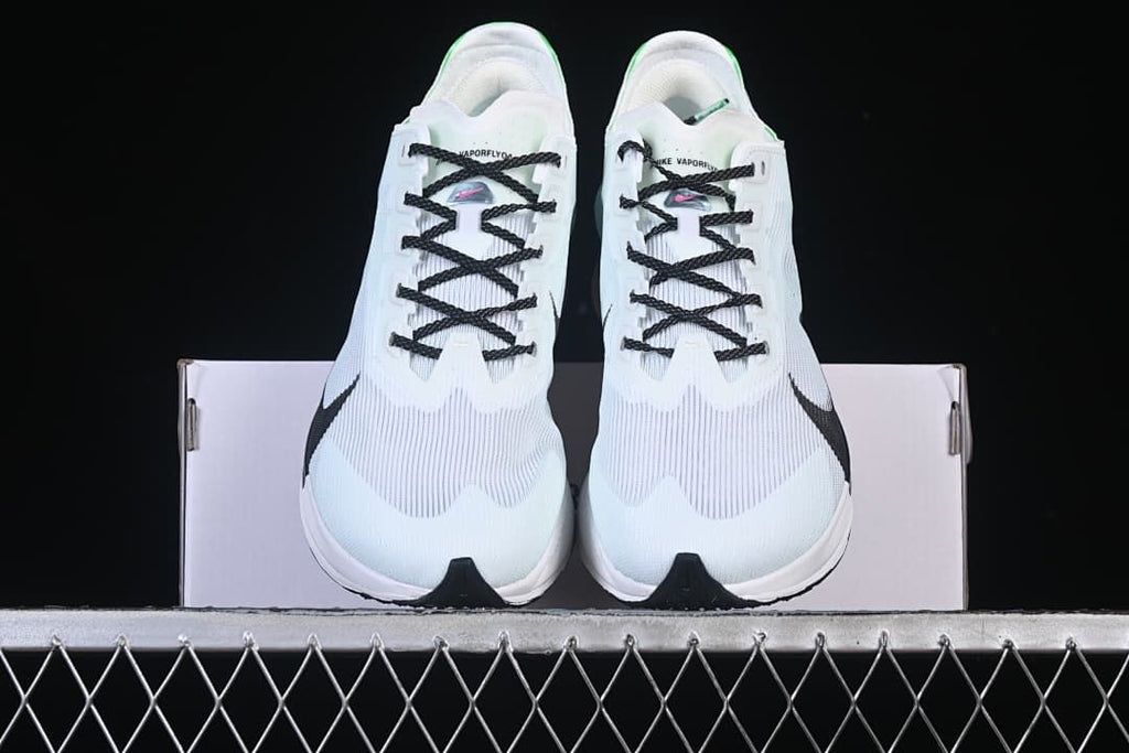 Front view of the pair of white running shoes displayed on a box