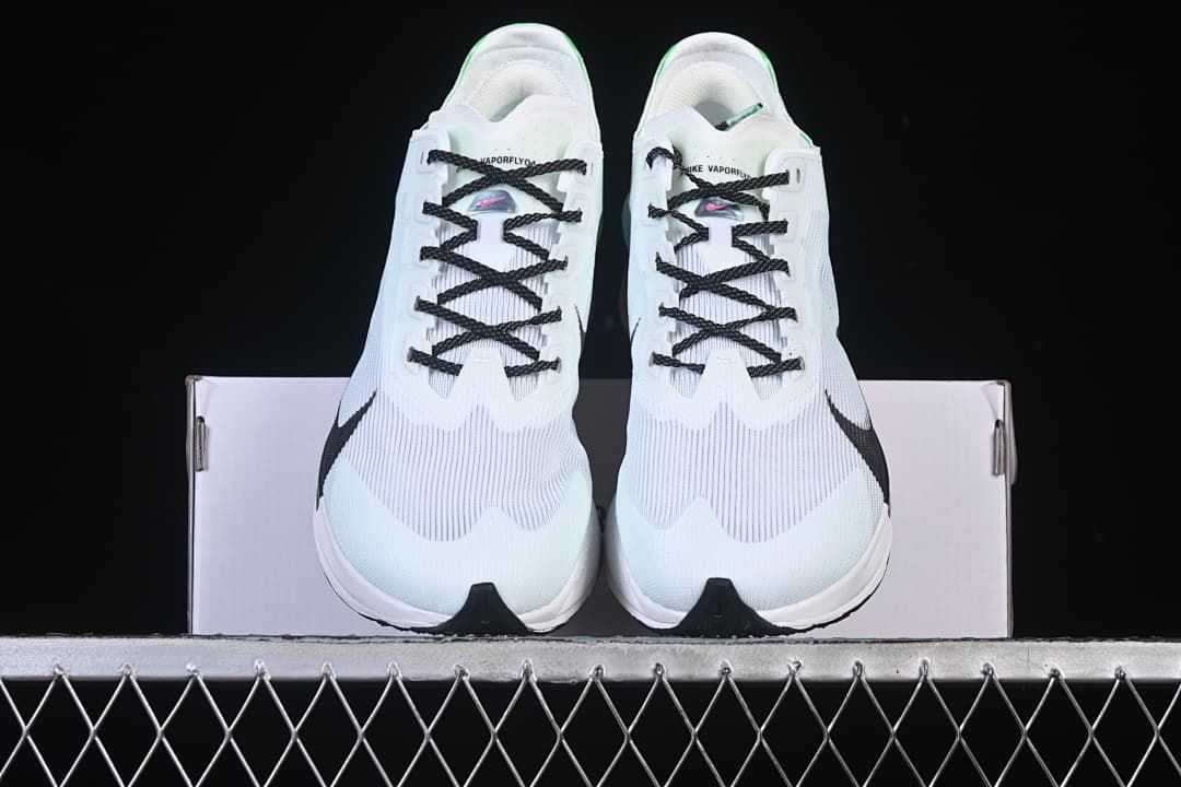 Front view of the pair of white running shoes displayed on a box