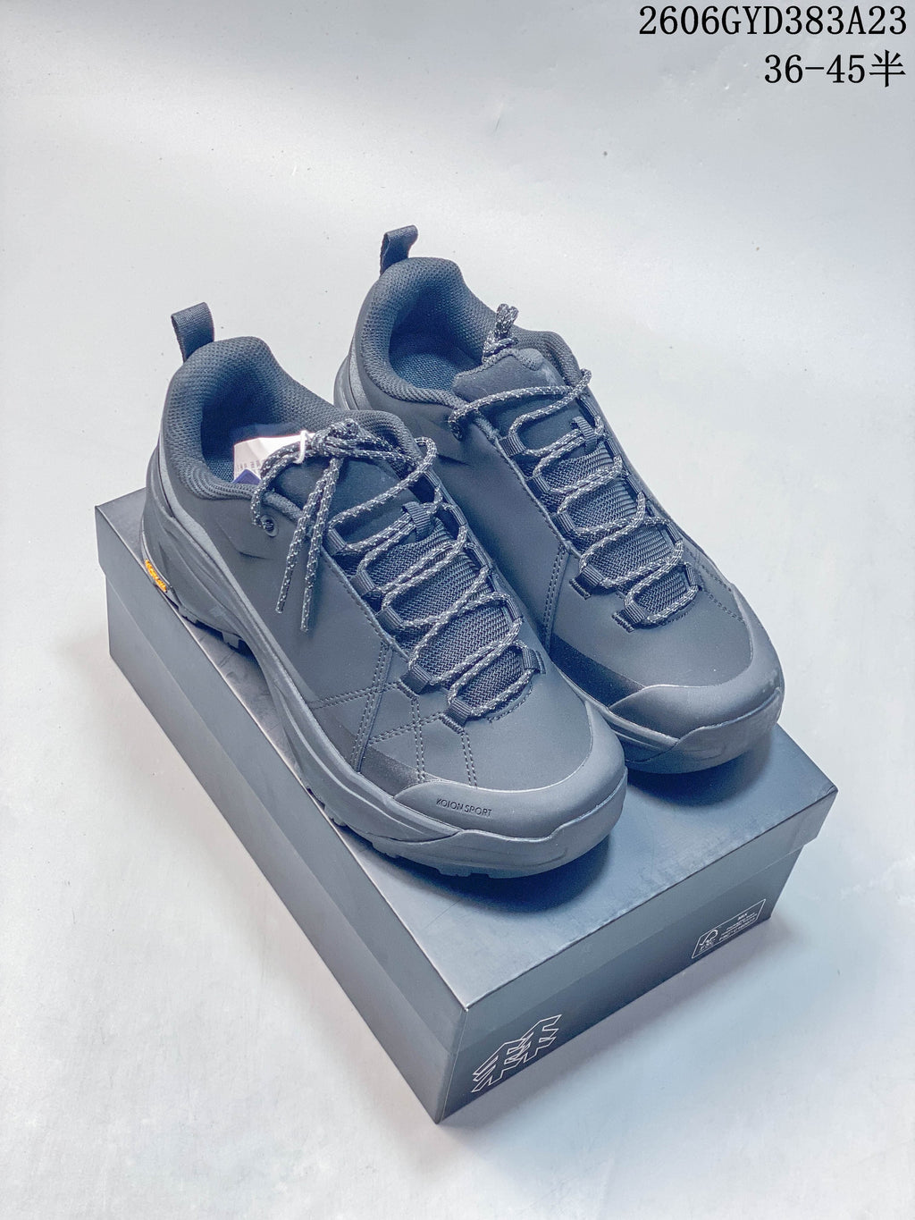 Pair of dark gray Kolon Sport low-cut hiking sneakers on a box