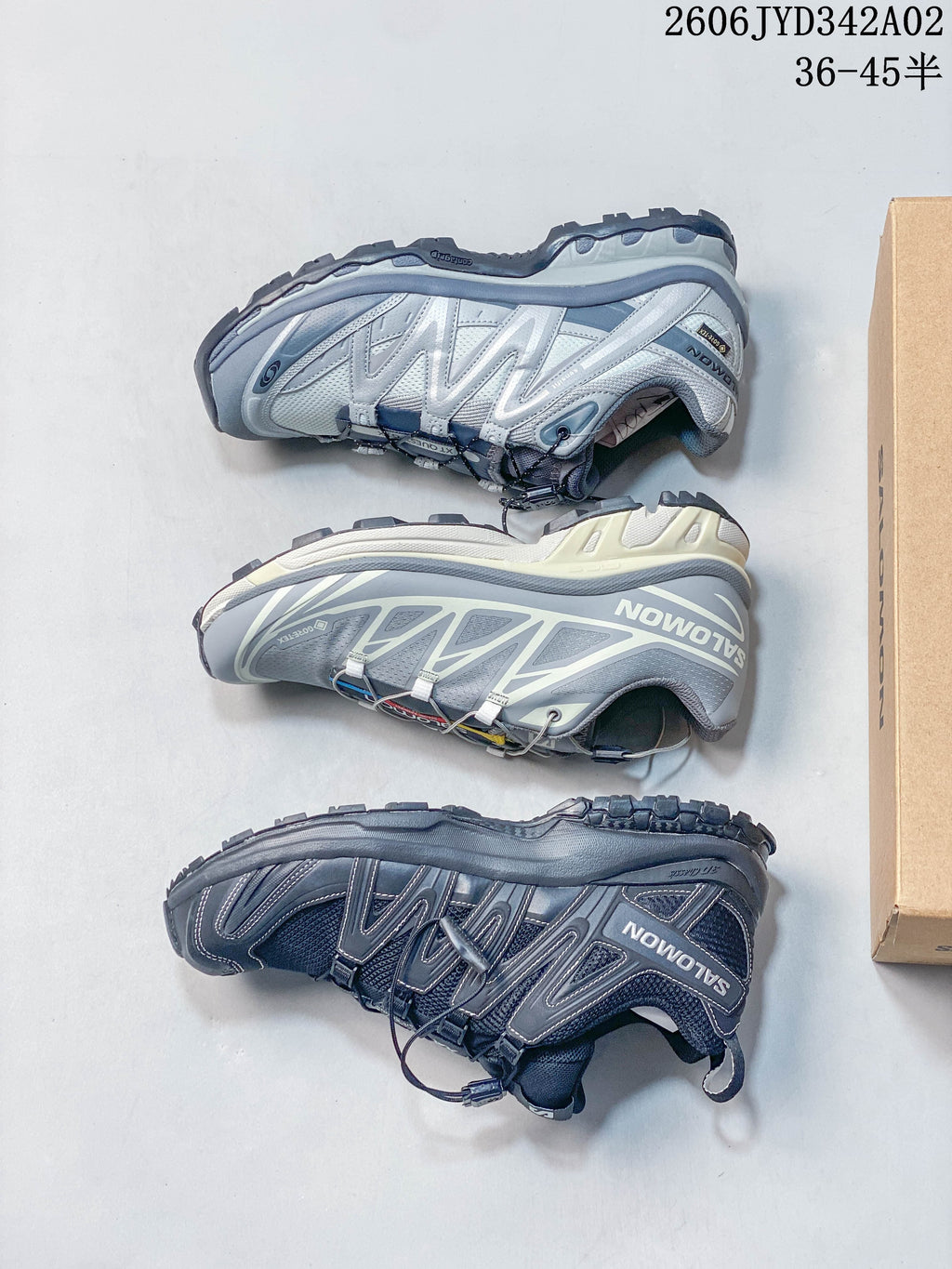 Three Salomon trail-style shoes shown in different grey colorways