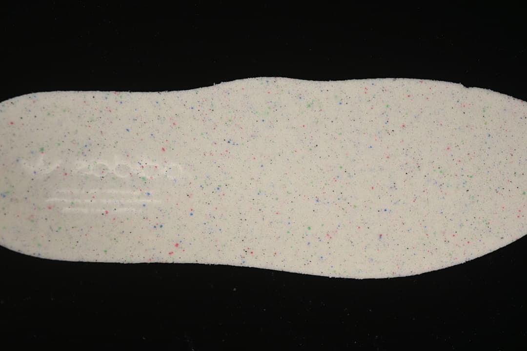 Close-up of a light-colored shoe insole with multicolor speckles