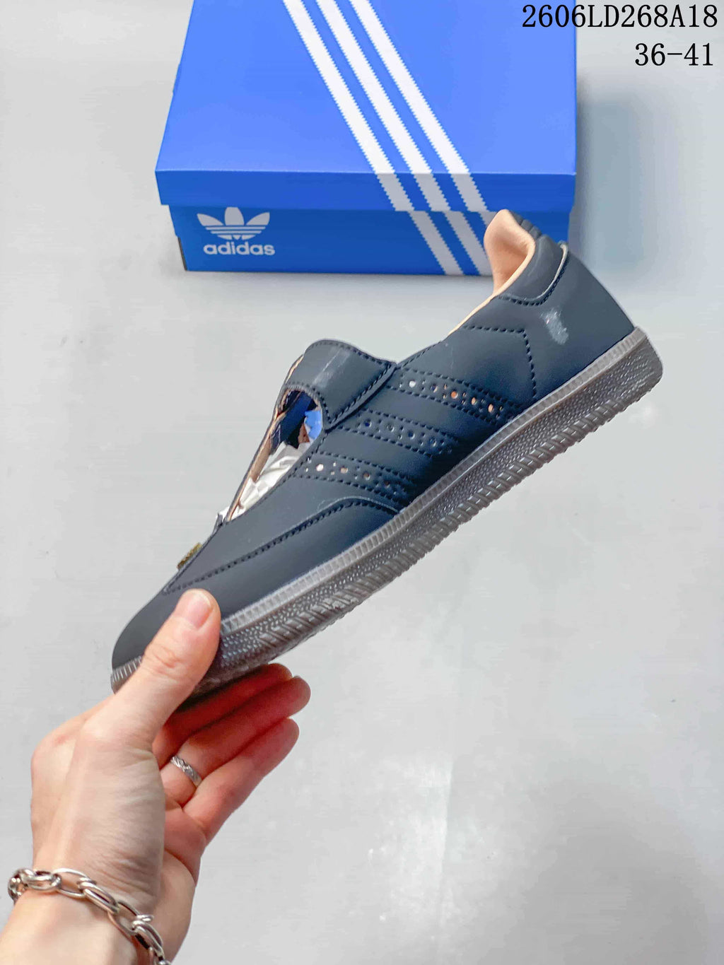 Side profile of a dark gray Samba Jane shoe with perforated detailing and T-strap