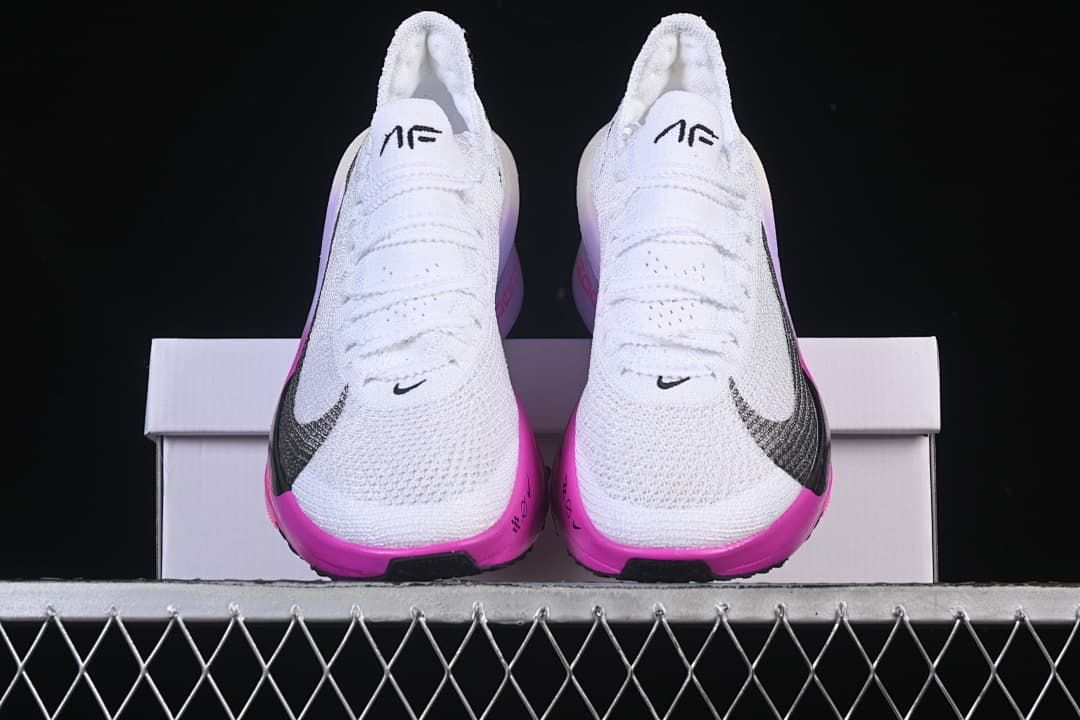 Front view of the pair showing white uppers and bright pink accents.