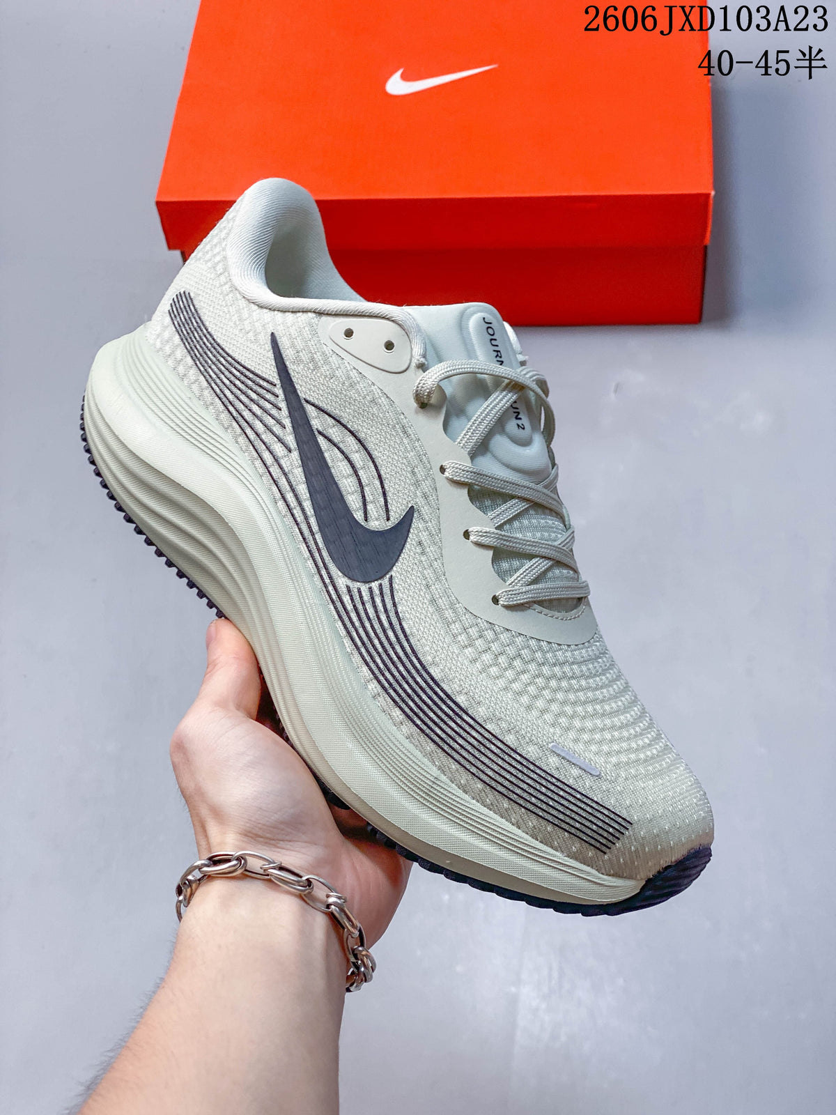 Angled side view of the light gray Nike running shoe
