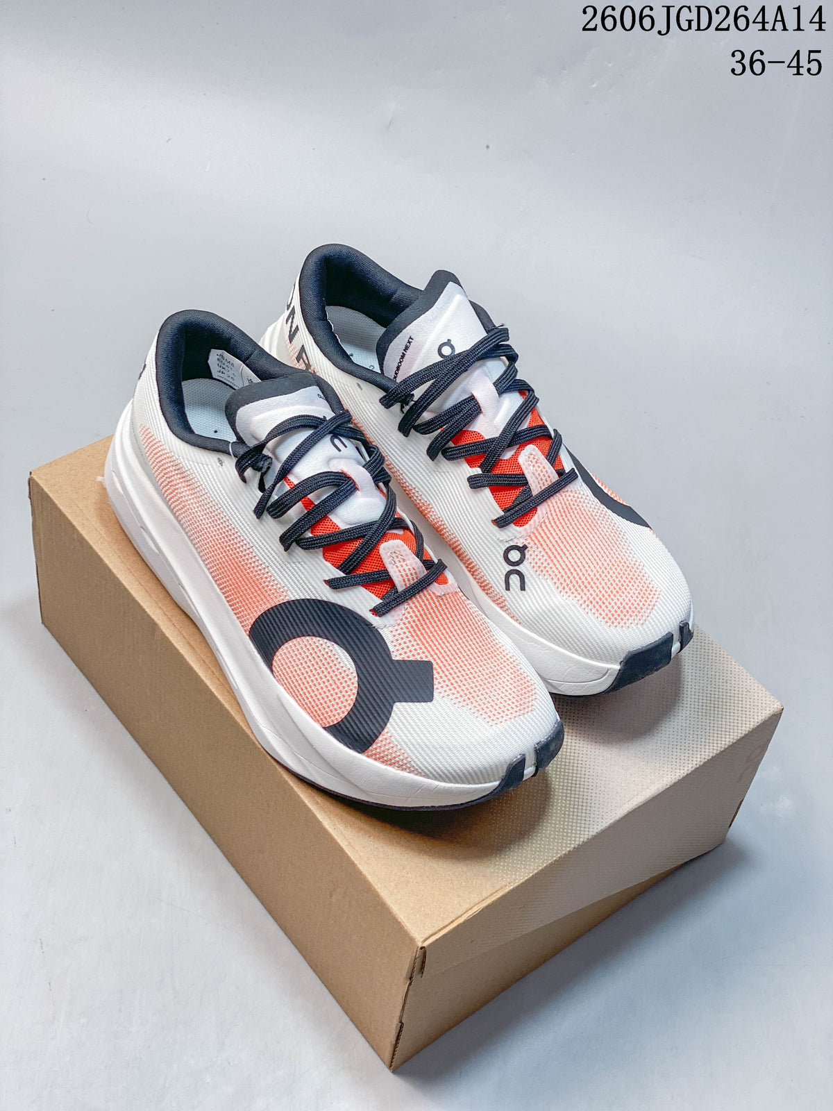 Pair of white and coral On Cloudboom Volt running shoes with dark laces, shown on a box.