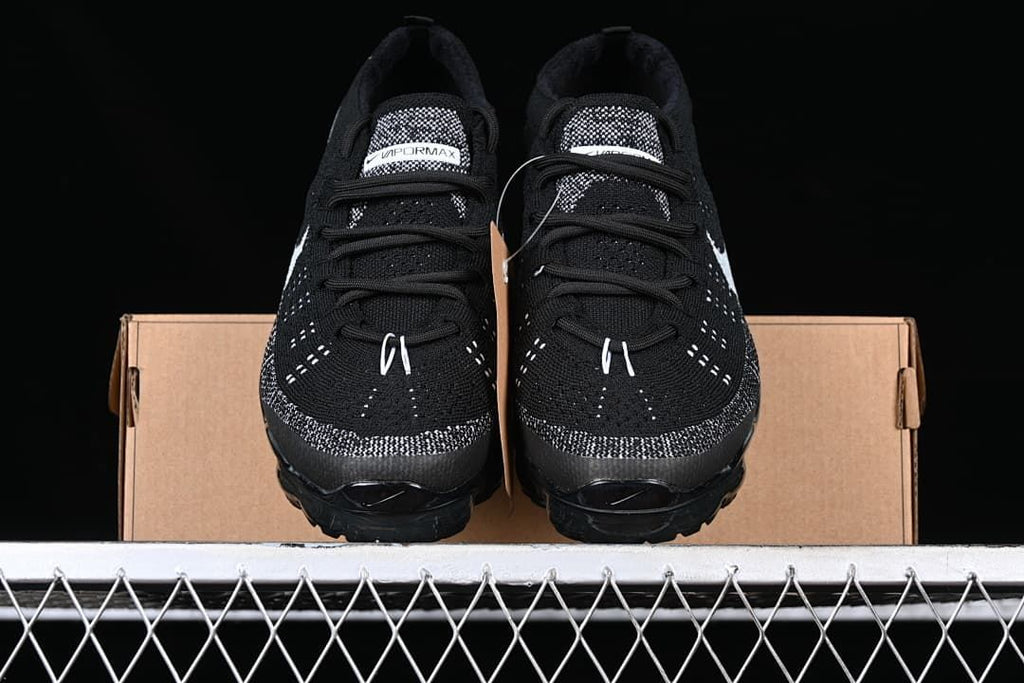 Front view of the pair of black and white Flyknit sneakers