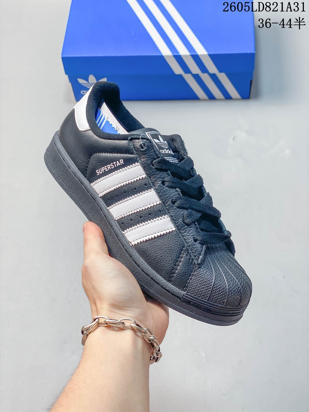 Dark navy adidas Superstar sneaker with white stripes and a textured shell toe.