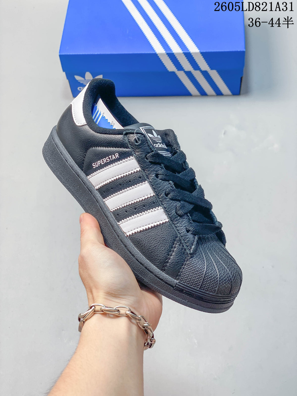 Dark navy adidas Superstar sneaker with white stripes and a textured shell toe.