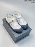 White Mary Jane flats with dark trim, textured dark toe caps, and buckle straps; size range 35–40 shown.