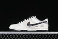 Side view of a white and gray Nike Dunk Low with patterned black Swoosh, black laces, and black outsole