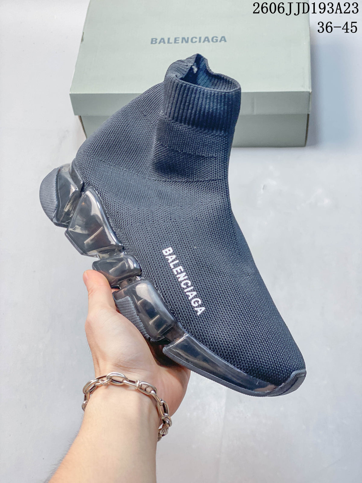 Angled view of a gray sock sneaker with a ribbed collar and segmented sole