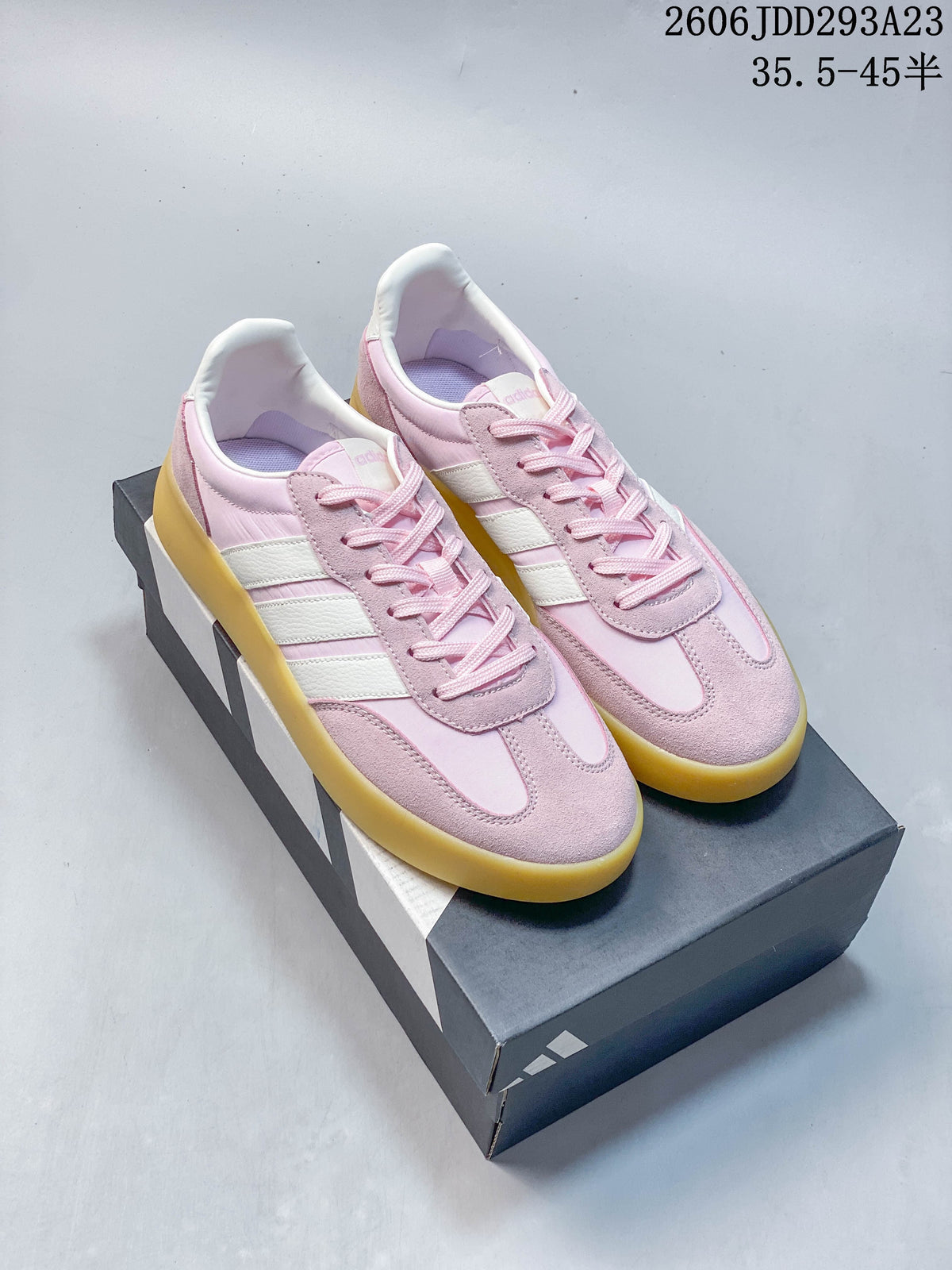 Pair of pink and white Adidas Barreda Decode sneakers with gum-colored soles