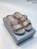 Pair of taupe ECCO double-buckle slide sandals shown on a box.