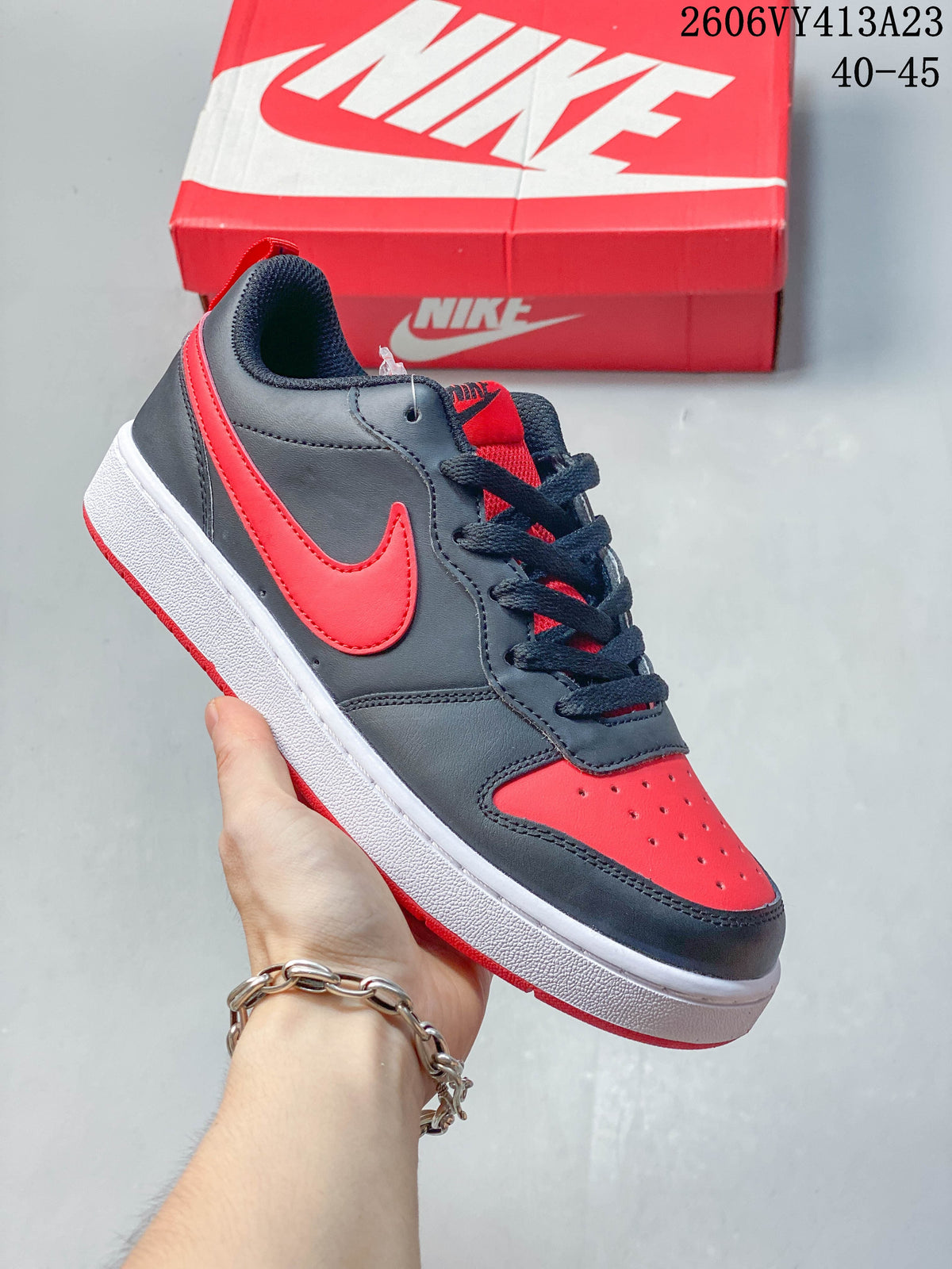 Dark gray low-top sneaker with bright red Swoosh and toe accents