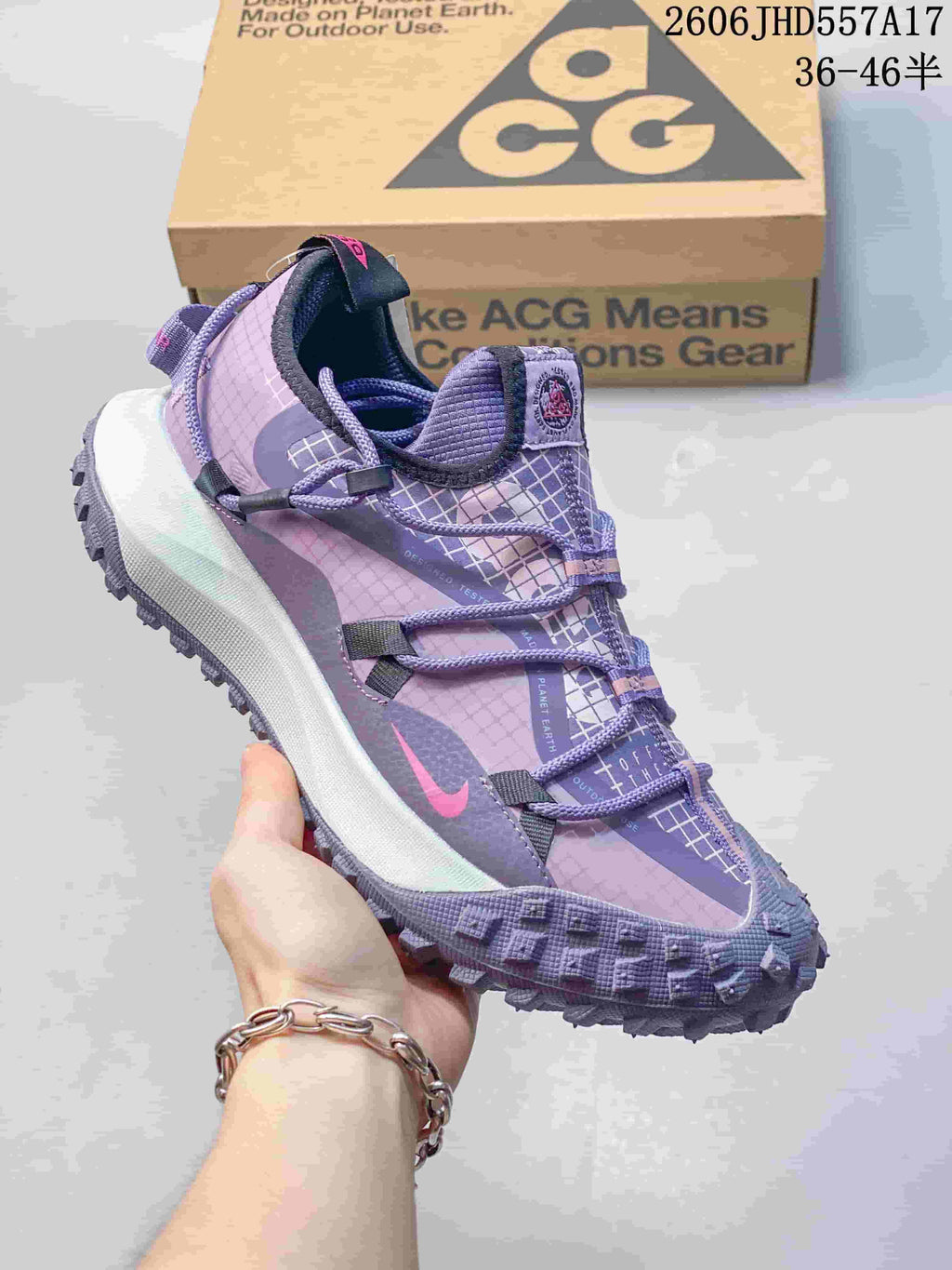 Nike ACG Mountain Fly sneaker in lavender and purple with patterned panels and cord laces.