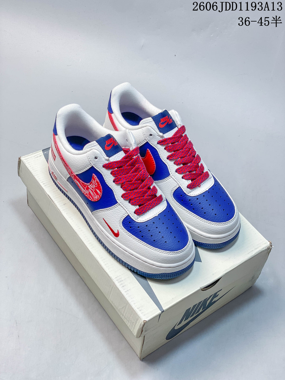 White, blue, and red Nike Air Force 1 low-top sneakers shown with a shoe box