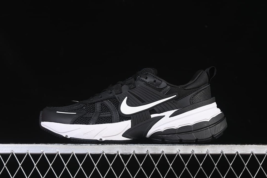 Side view of black Nike V2K Run shoes with a white Swoosh and two-tone sole.