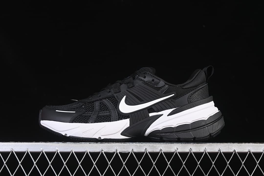 Side view of black Nike V2K Run shoes with a white Swoosh and two-tone sole.