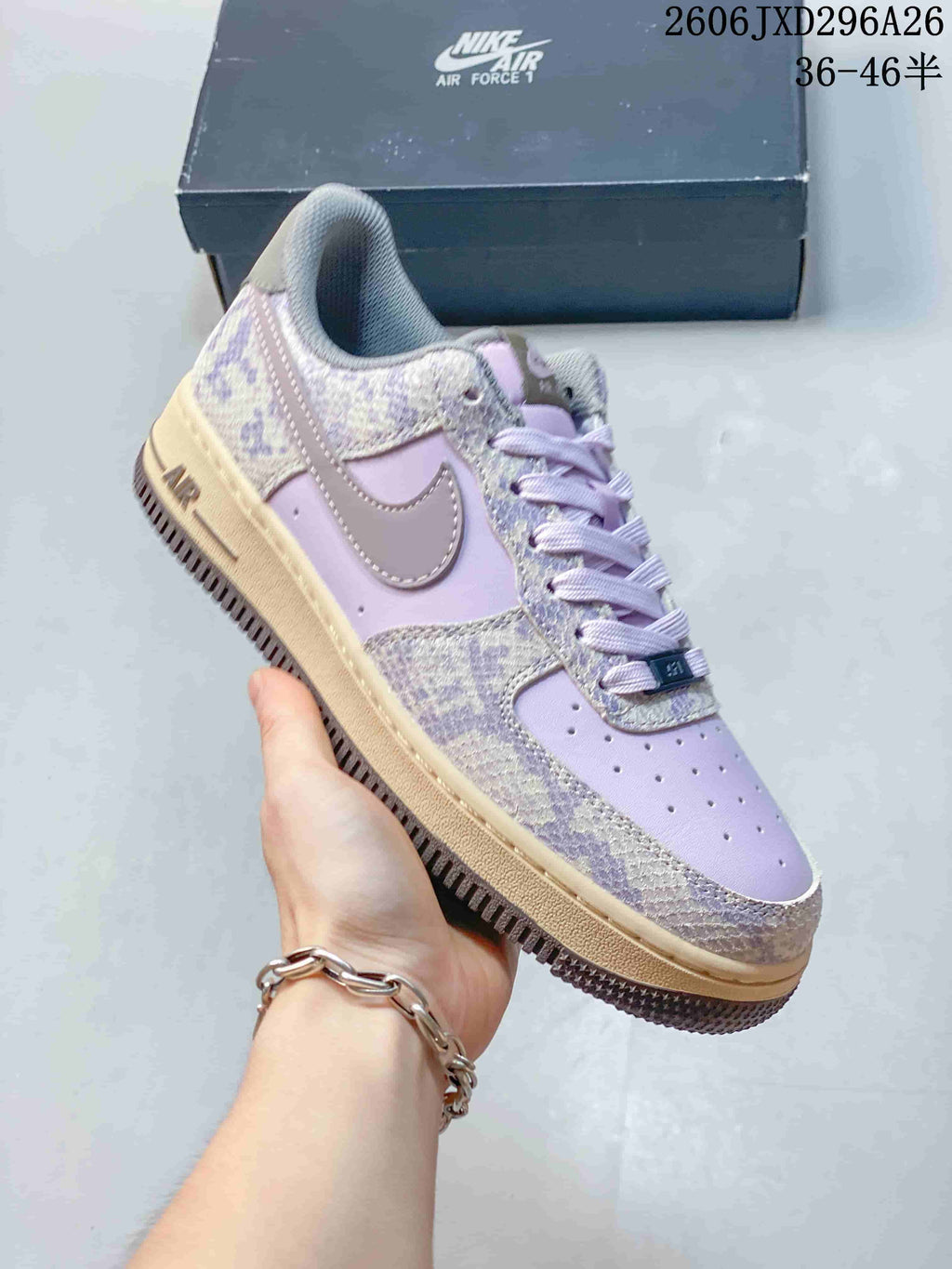 Close-up of a lavender Nike Air Force 1 sneaker with patterned overlays and a beige-toned sole