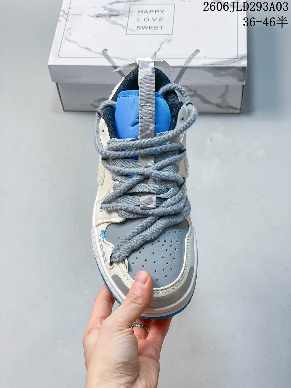 Front view showing perforated toe, gray laces, and blue tongue