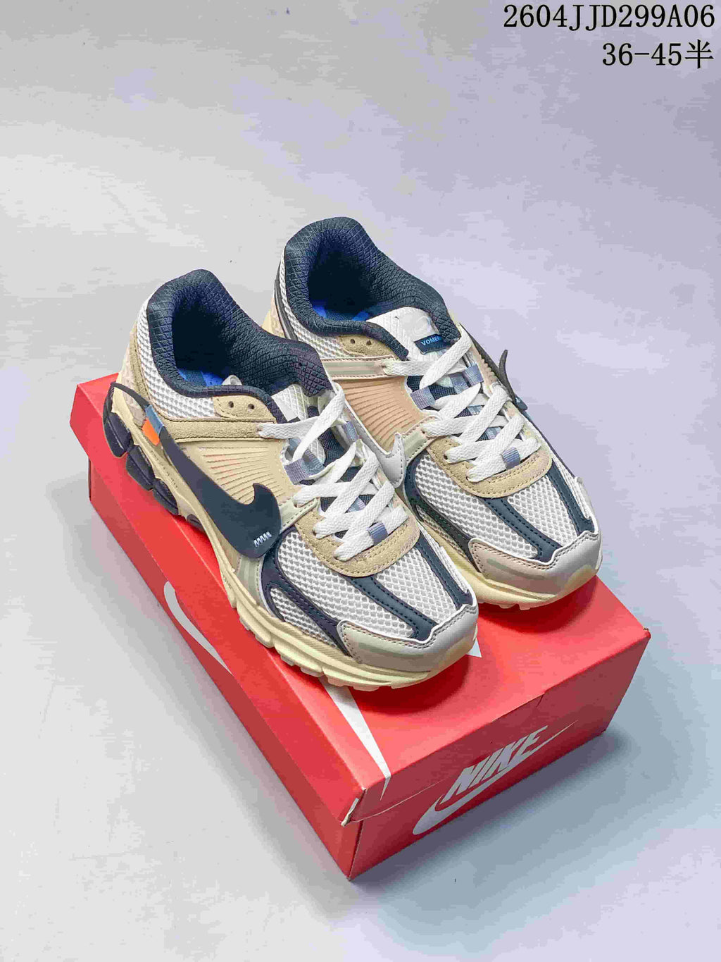 Pair of Nike Zoom Vomero 5 sneakers in a dark navy and light neutral color combination.