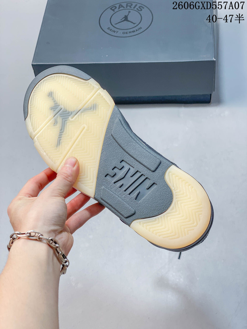 Underside of a Jordan Air Jordan 5 sneaker showing a cream-colored patterned outsole and gray midfoot section.