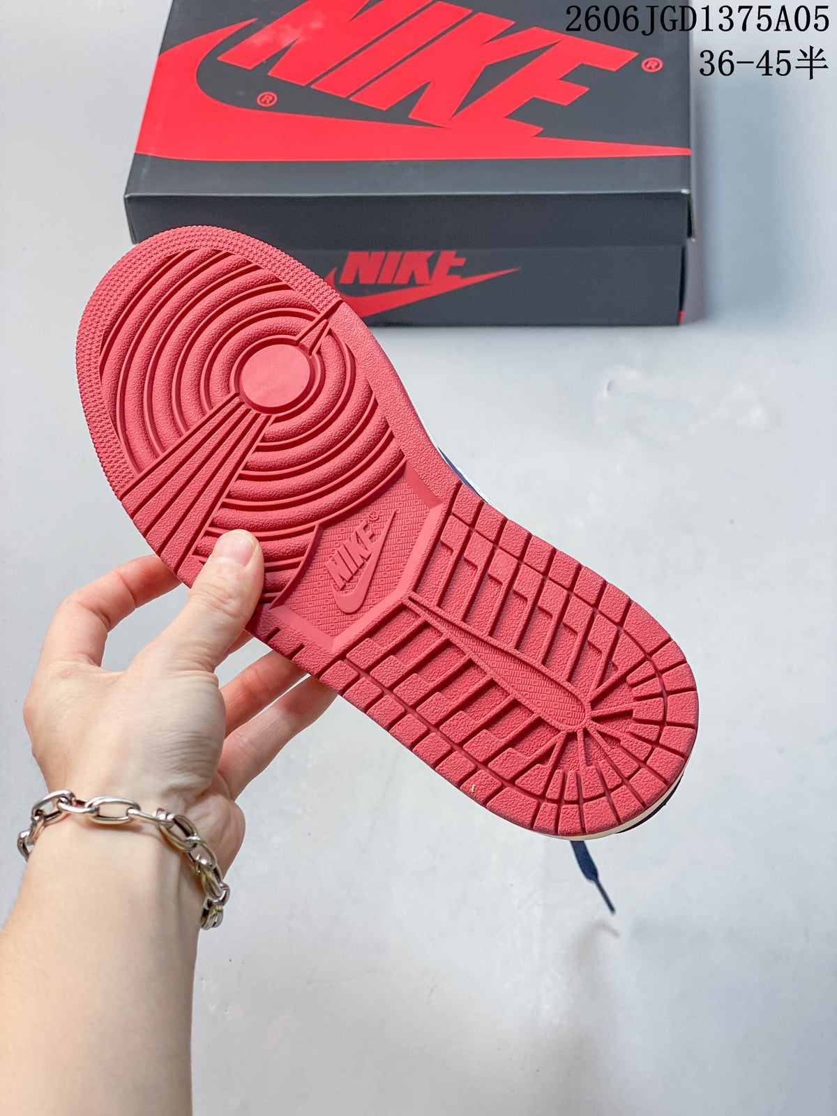 Red outsole of a blue and white Jordan 1 Low sneaker