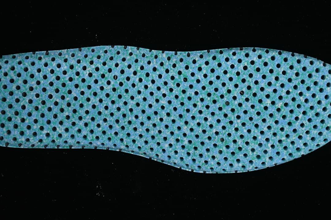 Blue perforated shoe insert shown from above