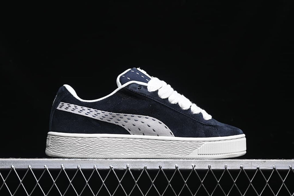 Side profile of the navy sneaker with a light-colored stripe and sole