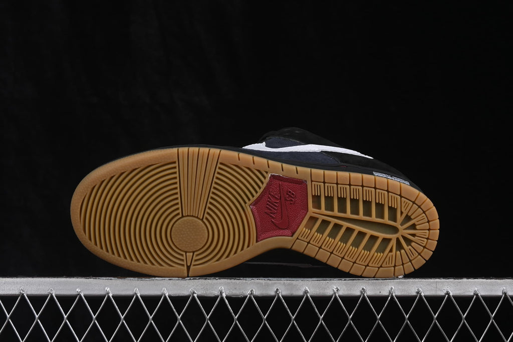 Underside of a Nike SB Dunk Low sneaker showing the gum-colored rubber outsole and circular traction pattern.