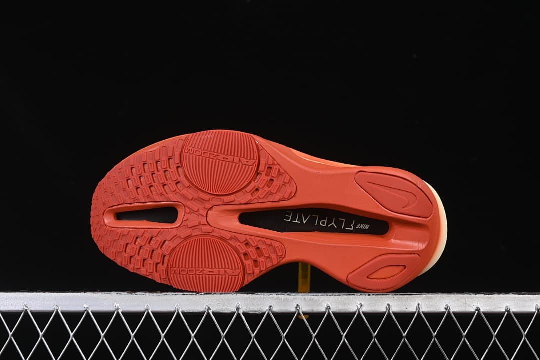 Underside view showing the coral-orange patterned outsole.