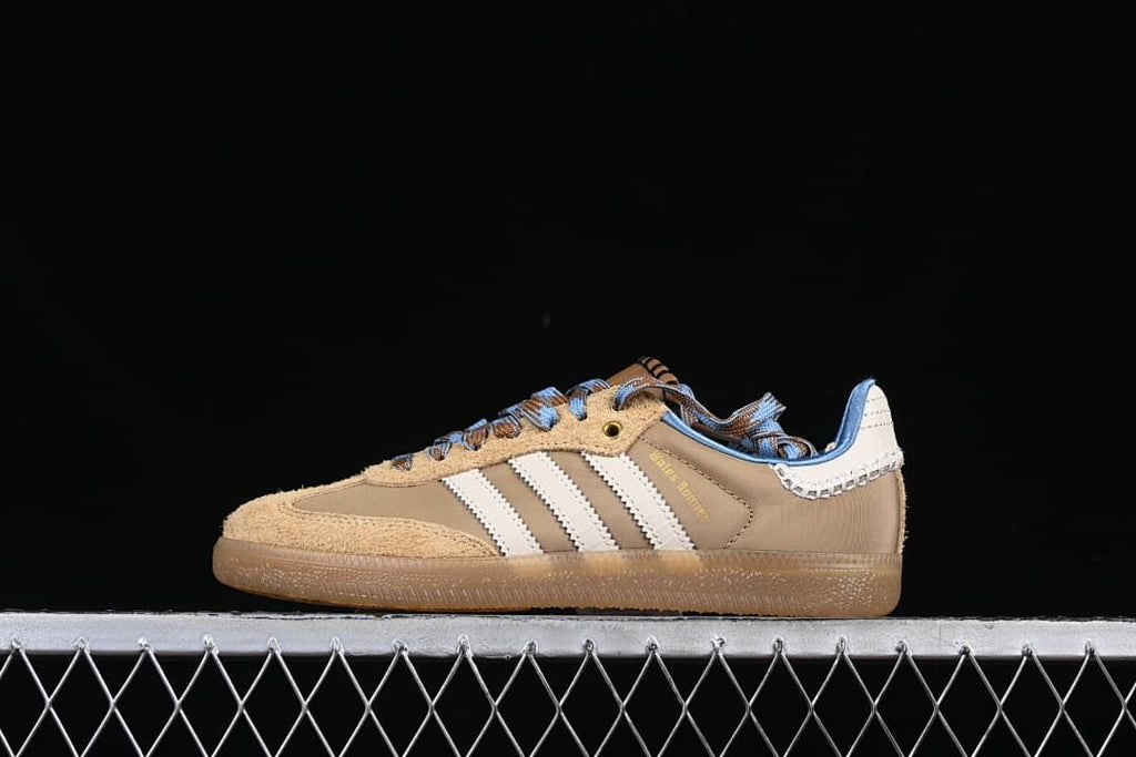 Side view of taupe and tan adidas Wales Bonner Samba sneakers with cream stripes, blue accents and gum-look outsole