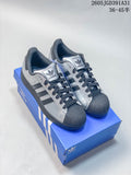Pair of silver Adidas Superstar sneakers with dark shell toes and dark laces on a blue shoe box.